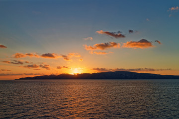Naklejka premium The Southern tip of the Dardanelles with the Sun rising over the Gallipoli Peninsula and the light reflecting in the calm waters.