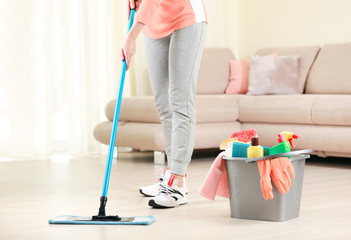 Woman clean the floor,girl clean up the room,bucket with sanitary items. - obrazy, fototapety, plakaty