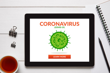Coronavirus, covid-19 concept on tablet screen with office objects on white wooden table. Social distancing. Top view