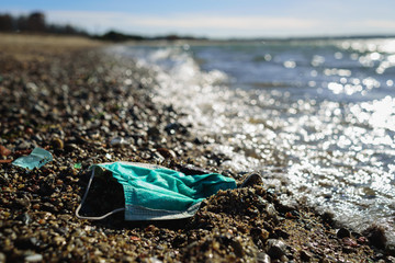 Dirty used medical mask on beach