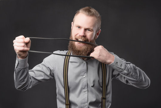 Handsome young man presents car parts on a gray background. The concept of sales and testing of goods