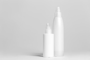 Set of cosmetic products in white and grey containers on light background.