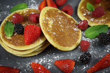 Fototapeta na wymiar pancakes aux fruits rouges sur une ardoise
