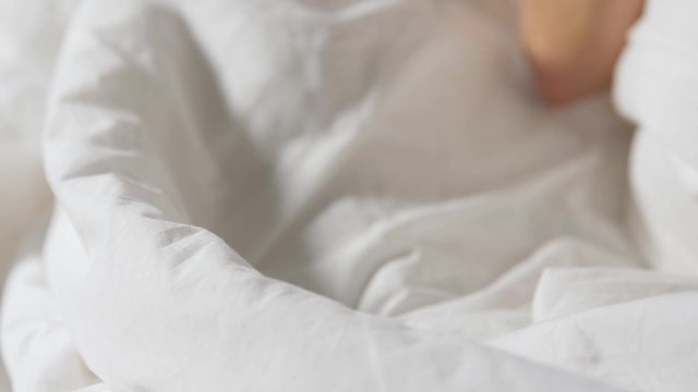 morning, breakfast and people concept - hands of woman drinking coffee in bed