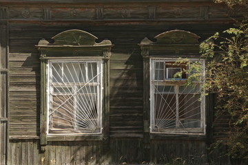 Ornamental windows with traditional national carved frames and Soviet symbolics on wooden rural...