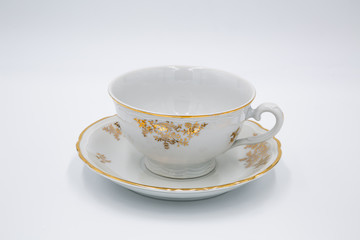 Vintage white  tea cup with golden design in classic style isolated on white background