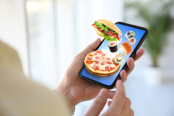 Woman using smartphone for ordering food online, closeup. Delivery service during quarantine