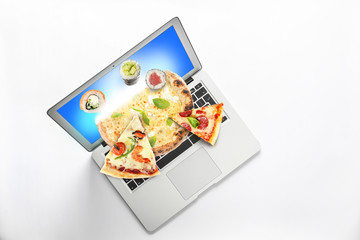 Modern laptop with open page of online food delivery service on white background, top view