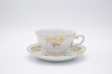 Fototapeta premium Vintage white tea cup with golden design in classic style isolated on white backg
