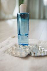 blue plastic bottle with antibacterial soap and antibiotic tablets. quarantine