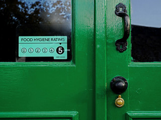 Food Hygiene Rating 5, faded sticker on old green door