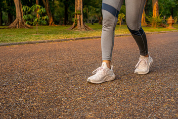 Young woman walking exercise on a brown street with white shoes exercising