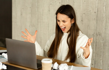 Fail at work. Freelance girl screams at laptop in workplace