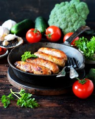 Homemade chicken (turkey) sausages fried in a pan. picnic. rustic