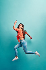 Fototapeta na wymiar Beautiful young attractive careless girl jumping having fun fooling flying isolated on bright vivid turquoise color background. Concept of carefree and cheerful mood.Full length body size view.