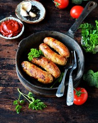 Homemade chicken (turkey) sausages fried in a pan. picnic. rustic