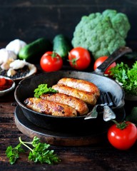Homemade chicken (turkey) sausages fried in a pan. picnic. rustic