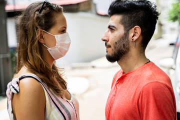 Naklejka premium Young woman with a protective mask facing her couple