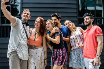 A group of friends of different ethnicities making a selfie in the street