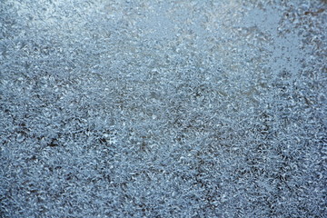 White blue hoarfrost crystals close up background texture on glass