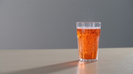 Orange carbonated drink in a glass. Orange soda fresh and cold yellow lemonade drink.
