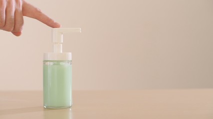 Female hands squeeze liquid soap out of the dispenser. Wash your hands. Coronavirus or COVID-19 prevention.