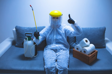 Scientist with protective suit and face mask, bio hazard sprayer for decontamination agaist...