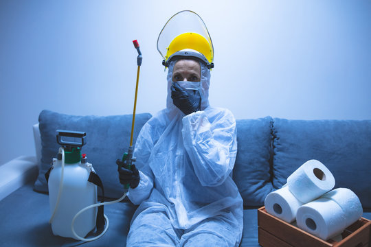 Scientist with protective suit and face mask, bio hazard sprayer for decontamination agaist viruses, germs - toilet paper stock paranoia at home, waiting for end of days.