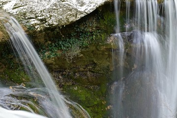 waterfall in spring in a gorge surrounded by young foliage