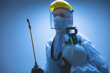 Scientist holding chemical sprayer for sterilization and decontamination of viruses, germs, pests,...