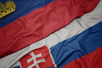 waving colorful flag of slovakia and national flag of liechtenstein.