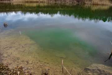 Blue water in an old abandoned quarry closeup.