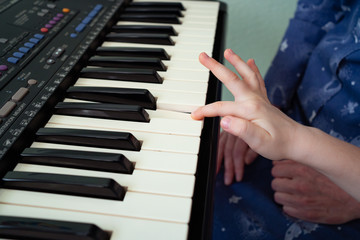Obraz premium child hands black white piano keys synth. close-up