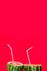 Creative image of romantic couple. Food fashion image. Two watermelon juice with a straw over red background