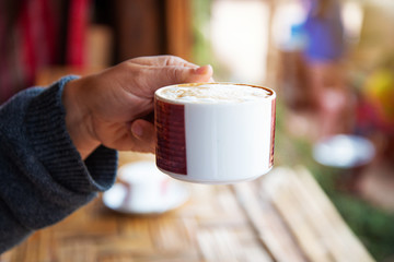 Drinking coffee in worm tone.