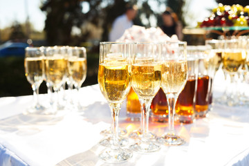 Elegant glasses with champagne standing on serving table during celebration