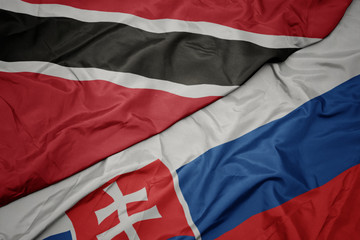waving colorful flag of slovakia and national flag of trinidad and tobago.