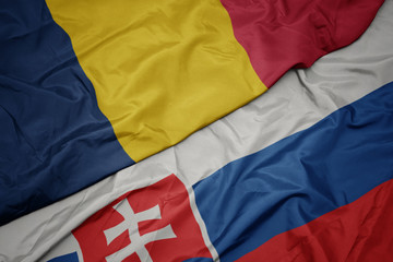 waving colorful flag of slovakia and national flag of chad.
