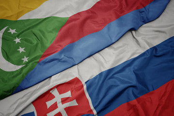 waving colorful flag of slovakia and national flag of comoros.