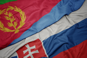 waving colorful flag of slovakia and national flag of eritrea.