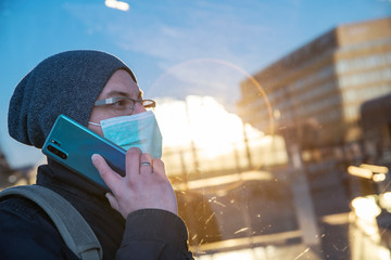 Virus protection in the city and outdoor while coronavirus. Portrait of man in face mask talking on...