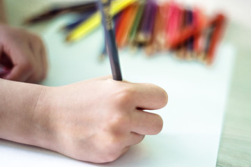 Close up cropped picture of drawing childs hand with pencil. Idea how to spend time during quarantine in preschool and school during pandemic of covid-2019