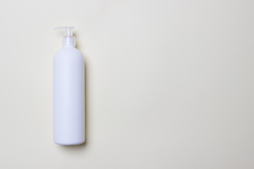 white bottle with cleaning agent on colored paper background with copy space