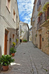 A narrow street between the old houses of the medieval village of Oratino, in Italy.