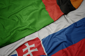 waving colorful flag of slovakia and national flag of zambia.