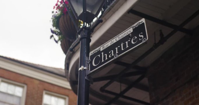 Chartres New Orleans Street sign with NOLA Decor in the background as they move in slow motion.