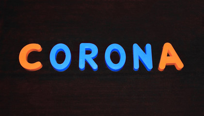 Corona word written with different colored letter blocks on a dark background