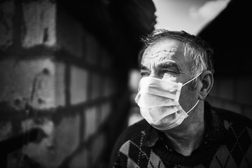 black and white photo of an elderly man in a white mask