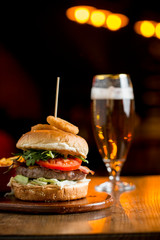 Burger of beef meat with melted chedar cheese, bacon,tomato, rocket salad with fried onion and spicy fries