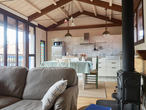sof&aacute; gris en primer plano con cocina comedor al fondo techos altos de madera en alojamiento apartamento